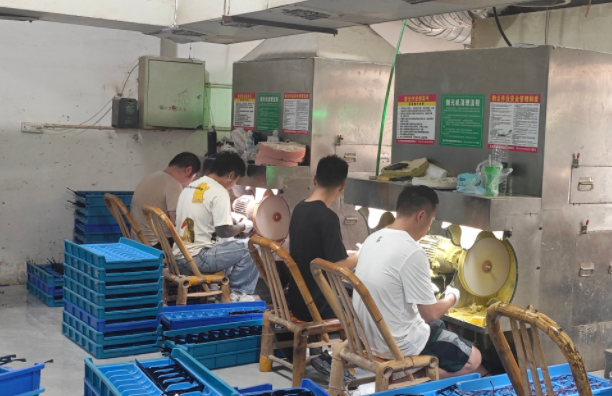 A close-up of a polisher's hands skillfully holding a frame against a soft cotton wheel