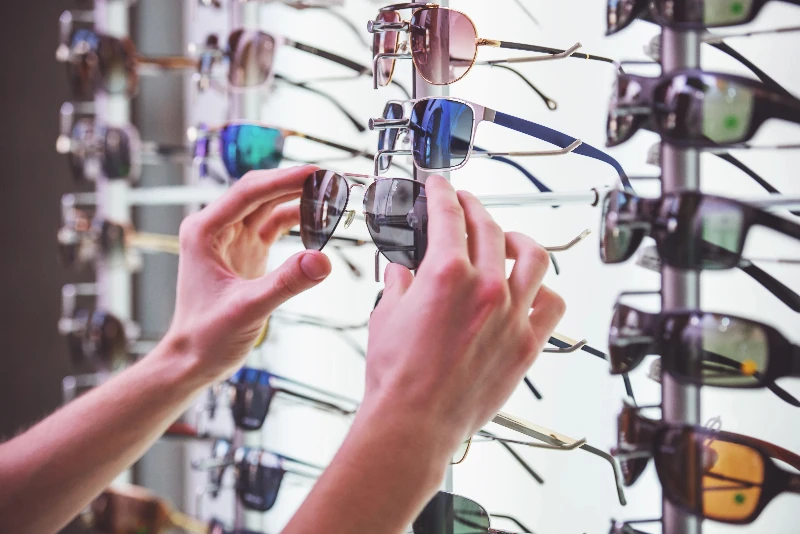 Selecting Sunglasses From A Wholesale Display.