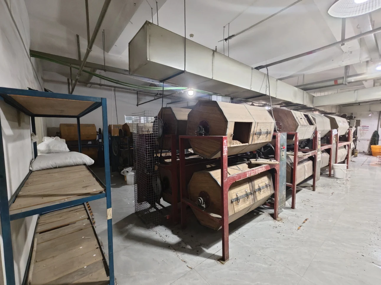 Traditional wooden barrel polishing area used for smoothing high-quality acetate frame surfaces.